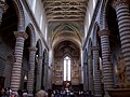 Orvieto Cathedral in Italy has round striped columns and an open wooden roof.