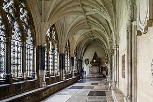 A stone corridor with a vaulted ceiling and stone memorials on the walls and floor