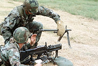 The M60 machine gun crew member responsible for a hot barrel change was issued protective asbestos gloves to prevent burns to the hands