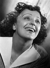 Photo en noir et blanc d'une jeune femme trentenaire souriante.