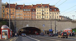 Tunnel avec, par dessus, une route et des bâtiments.