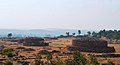 Group of stupas. The Sanchi stupas appear far away on the horizon.