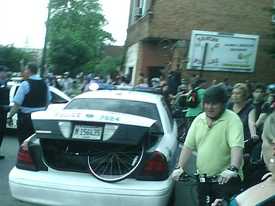 A cyclist at the Chicago Critical Mass is arrested for public drinking.