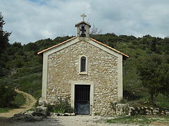 Façade de la chapelle rustique de Saint-Brice : une simple entrée pourvue d'une grille, surmontée d’une niche