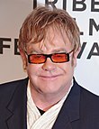 Profile picture of Elton John, a White man wearing orange sunglasses