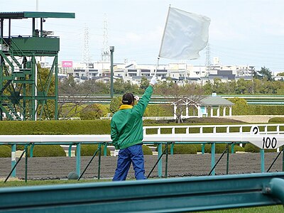 合図を受け白旗を振る発走委員(下)