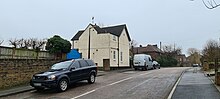 White painted detached house in urban setting