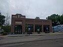 Excelsior Library, a modern brick building with three large street-facing windows and a glass entrance over which the word "Library" is imprinted in cement.