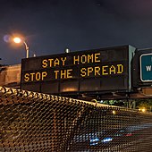 Variable-message sign reading "STAY HOME, STOP THE SPREAD"