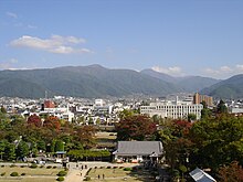 Photographie d'une ville vue de dessus, avec des montagnes à l'horizon.