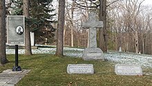 Large granite cross in the background with two smaller granite stone in the foreground