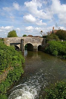 Three arch stone bridge over water.