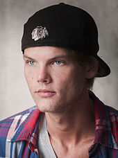 Avicii looking to the right, wearing a black cap.