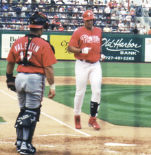 A man in a Philadelphia Phillies' uniform walking from third base to home plate