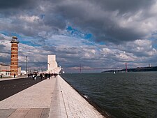 L'area lungo il Tago nei pressi del Monumento alle Scoperte, con il Farol de Belém e, sullo sfondo, il Ponte 25 aprile. Sulla sponda destra del fiume, è visibile il Santuario nazionale di Cristo Re ad Almada.