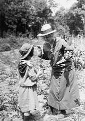 Lou Henry Hoover stands in a field with a young girl