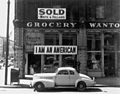 A Japanese American unfurled this banner the day after the Pearl Harbor attack; Lange photographed it in March 1942, just prior to his internment.