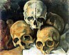 Painting by Paul Cézanne depicting four human skulls stacked in a pyramid, painted in a pale light against a dark background