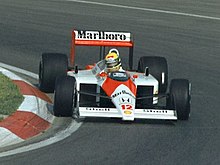 Photo of Ayrton Senna driving a red and white McLaren on a race track