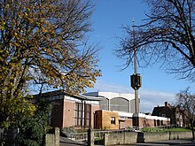 An Art Deco church of brick and concrete construction with a detached spire-cum-bell tower