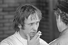 Photo en noir et blanc de Chris Amon, tenant une cigarette