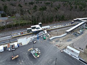 An aerial view of a railway station with two footbridges under construction