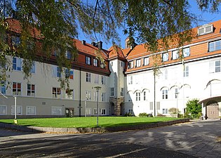 Skolgården med tillbyggnaderna från 1916 och 1919.