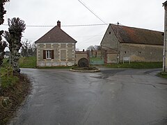 Meule de moulin érigée en monument à un carrefour.