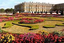 Photo représentant le château de Versailles vu des jardins sud-ouest.