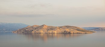 Vista de Prvić, uma ilha desabitada na parte croata do mar Adriático, localizada no Golfo de Carnaro (Kvarner). É a maior das chamadas ilhas Senj, um grupo de pequenas ilhas e ilhéus localizados ao largo da costa da cidade continental de Senj, situada entre as ilhas maiores de Krk e Rab. Prvić tem uma área de 12,76 quilômetros quadrados, o que a torna a maior ilha desabitada da Croácia. Os abutres-fouveiros (Gyps fulvus), uma espécie de ave protegida, são conhecidos por se reproduzirem em Prvić. Além disso, existem 17 espécies de plantas endêmicas que crescem nela. Por causa disso, a ilha é legalmente protegida como reserva botânica e de aves. (definição 4 575 × 2 068)