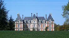 Photographie en couleurs de la façade en pierres et briques d'un château.