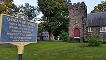 a picture of the marker with the stone church behind it