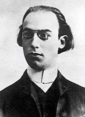 young white man with receding medium-length dark hair, in pince-nez