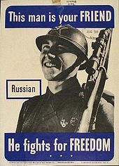 A poster with a photograph of a smiling soldier with a rifle resting on his left shoulder