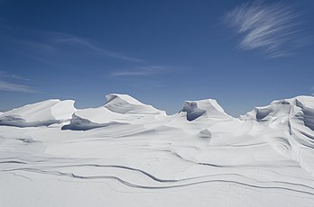 Nevado no Parque Nacional Pelister, município de Bitola, Macedônia do Norte. Nevado é um tipo de neve jovem e granular que foi parcialmente derretida, recongelada e compactada, mas precede a forma de gelo. Este tipo de neve está associado à formação de geleiras através do processo de nivação. O nevado que sobrevive a uma temporada completa de ablação se transforma em firn, que é mais antigo e ligeiramente mais denso. O firn eventualmente se torna gelo glacial − o gelo compactado e duradouro do qual as geleiras são compostas. A formação de geleiras pode levar de dias a anos, dependendo dos fatores de congelamento e degelo. O nevado é observado anualmente nas pistas de esqui. (definição 4 928 × 3 264)