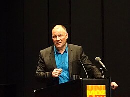 Middle-aged man standing behind a lectern