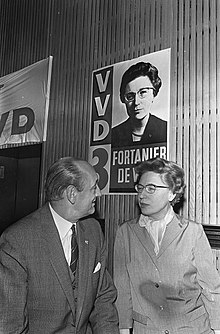 A black and white photograph of a woman and man talking