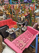 Portrait photo showing outdoor living room exhibit at Randyland. The photo shows outdoor furniture with coffee table, old phones, old TV set.