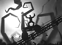 A silhouette of a man holding his arms in the air stands atop a wheeled platform ascending a diagonal girder. The backdrop is foggy and white, with silhouettes of curving trees and shapes visible.
