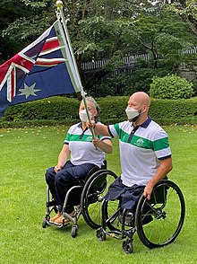 Daniela di Toro and Ryley Batt in wheelchairs jointly holding the Australian flag.