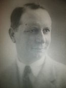Portrait en buste d'un jeune homme en cravate et souriant.