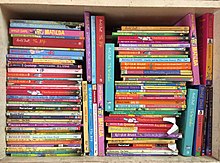 Bookshelf with stacks of books by Roald Dahl