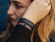 Model wearing elastic bracelet with text "you got this"