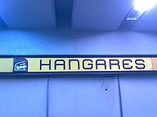 Picture of a wall sign featuring Hangares logo, a biplane inside a hangar.