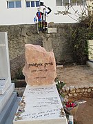 קברו של איינשטיין בבית הקברות טרומפלדור בתל אביב, ומעליו הפסל "יושב על הגדר", המתאר ידידות בין אדם חרדי (אורי זוהר) לזמר חילוני (איינשטיין)[158]