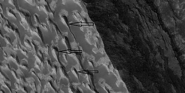 Layers and yardangs, as seen by HiRISE under HiWish program. Arrows point to some yardangs.