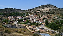 Pueblo con muchas casas de diversas formas. Se ven montañas al fondo en lo alto y las casas en un valle.