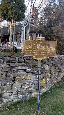 a picture of the marker with the porch of the new house in the background