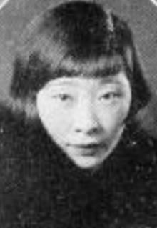 A young Chinese-American woman with dark hair bobbed with bangs, wearing a fur wrap