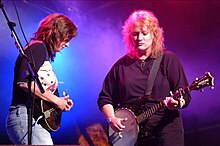 Indigo Girls strumming a mandolin and banjo onstage at Cambridge Festival in 2002